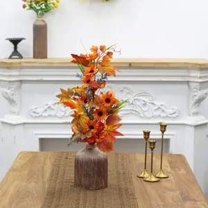 Close-up of autumn harvest artificial sunflower and maple leaf arrangement in rustic vase