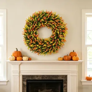 Fall artificial wreath hanging above a white fireplace mantel with pumpkins.