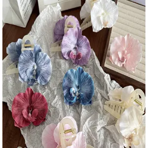 Detailed view of colorful silk orchid hair claws with realistic fabric flower petals.