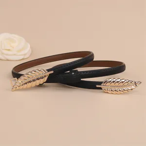 Detailed shot of women's thin black leather dress belt featuring elegant gold leaf metal buckles.