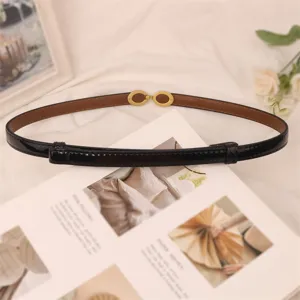 Thin black patent leather belt detail with gold metal interlocking buckle for dresses.