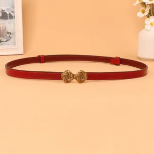 Close-up view of the red thin leather belt featuring a vintage metallic knot buckle detail.