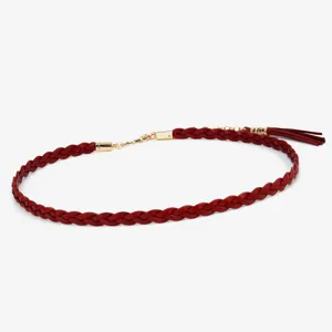 Detail shot of the elegant red braided leather waist belt showcasing gold metal hardware and tassel.