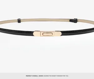 Close-up view of the slim black patent leather belt with a sleek gold-tone metal buckle detail.