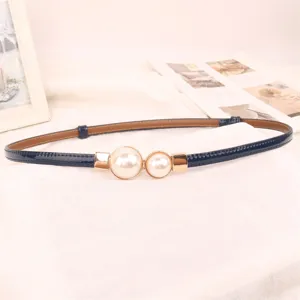 Close-up of elegant navy blue thin belt with two pearl decorations for dresses