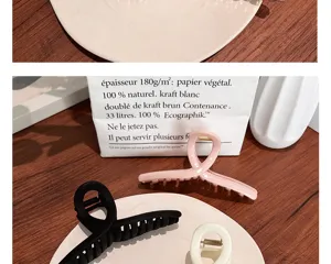 Gros plan de grandes pinces à cheveux minimalistes en finitions mates rose et noir