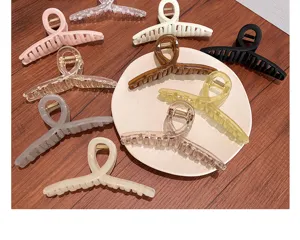 Vue détaillée de grandes pinces à cheveux colorées au design torsadé sur une assiette
