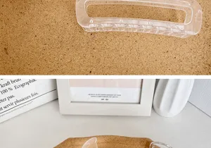 Nahaufnahme einer großen transparenten Haarklammer aus Kunststoff auf Korkgrund