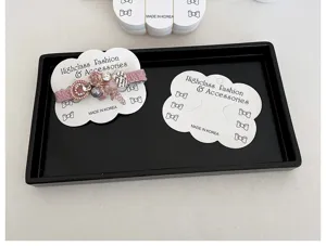 Gros plan de cartes blanches ondulées pour barrettes avec marquage coréen dans un plateau.
