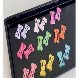 Pinzas para el cabello con forma de hueso en colores pastel y lunares en una bandeja