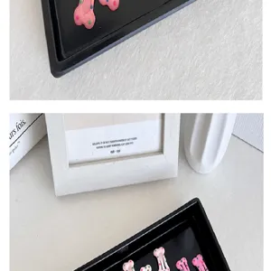 Primer plano de pinzas para el cabello con forma de hueso rosa y lunares