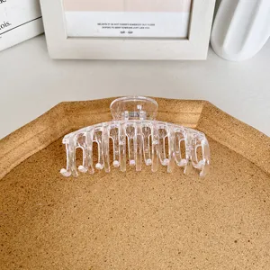 Große transparente Haarklammer für Damen auf einem minimalistischen Korktablett serviert
