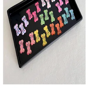 Primer plano de horquillas coloridas con forma de hueso y lindos patrones de lunares