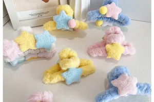 Vue détaillée de pinces à cheveux en peluche avec étoiles de couleurs pastel variées.
