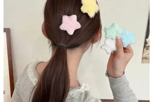 Nahaufnahme von süßen Plüsch-Stern-Haarclips in Pastellfarben, von Model getragen.