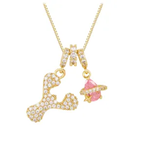 Close-up detail of the gold-plated letter Y pendant paired with a pink zircon Saturn charm