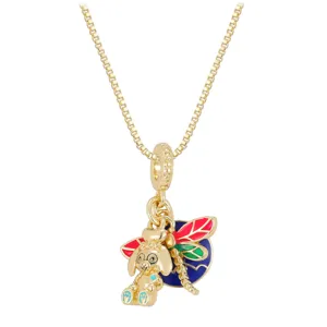 Detailed macro shot of a golden dog and colorful dragonfly enamel charm necklace