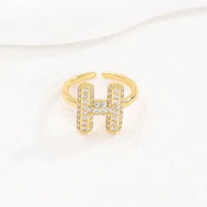 Detail van een gouden bubble-initiaal-H-ring met fonkelende pavé-steentjes voor dames.