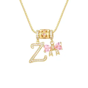 Detailaufnahme der vergoldeten Kette mit Zirkonia-Buchstabe Z und rosa Herz-Bogen-Anhänger.