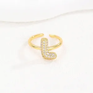 Detailopname van een vergulde open ring met kristal ingelegde ballonletter L goud