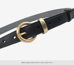 Detail view of black genuine leather belt with classic round brass metal buckle and loops.