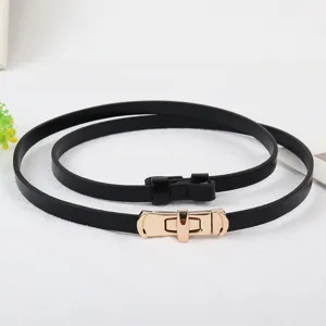 Detailfoto van een smalle zwarte lederen riem met gouden draaisluiting als kledingaccessoire.
