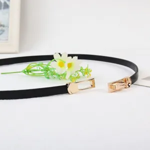 Smalle zwarte lederen damesriem met gouden metalen draaibare gesp voor elegante jurken.