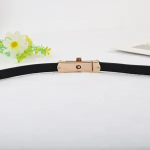 Slanke zwarte dames leren riem met gouden metalen draaisluiting, stijlvol en elegant.