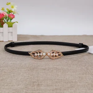 Details of the thin black leather women waist belt featuring gold leaf pearl decorative buckle.