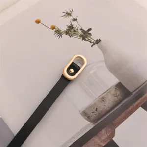 Narrow black leather belt for women with elegant gold oval buckle, perfect for dresses and suits.