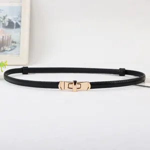 Detailed view of women thin black leather belt with elegant gold metal lock buckle accessory.
