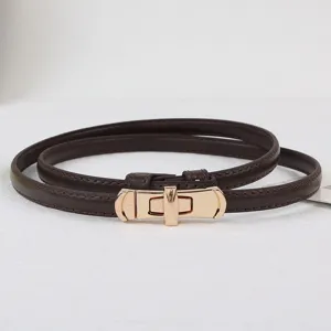 Women thin leather belt with metal lock buckle, elegant dress waist accessory detail.