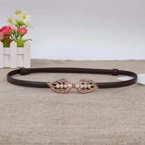 Slim brown leather belt featuring a delicate gold leaf pearl buckle detail for waist shaping.