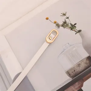 Minimalist thin white leather belt for women with elegant gold oval buckle accessory.