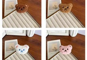 Vue détaillée de broches en peluche d'ours mignon en quatre couleurs sur un plateau