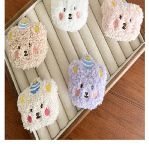 Détail macro de divers écussons DIY en peluche tête d'ours pastel sur un plateau