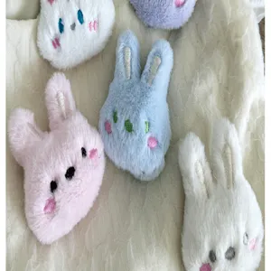 Gros plan de têtes de lapin en peluche douce aux couleurs pastel pour accessoires de cheveux