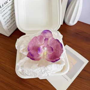 Elegant purple butterfly orchid hair clip with pearl center in minimalist gift box.
