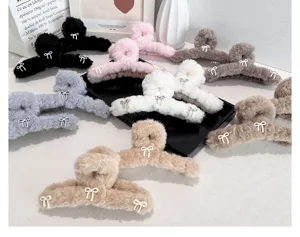 Collection of soft plush hair claw clips with delicate bow details in multiple colors.