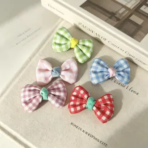 Detailed view of colorful checkered bow pet hair clips, cute handmade hair accessories.