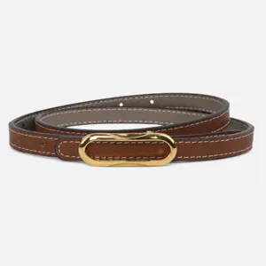 Vista detallada del elegante cinturón de cuero para mujer con hebilla dorada y reversible.