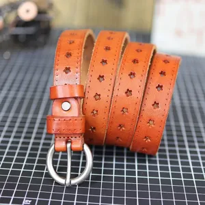 Brown genuine leather belt detail showing star cutout patterns and round metal buckle.