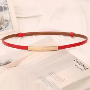 Élégante ceinture fine en cuir rouge pour femme avec une boucle en métal doré minimaliste.