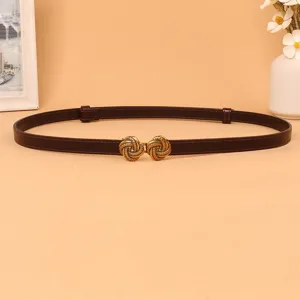 Detailed view of women's thin dark brown leather waist belt with vintage gold buckle.