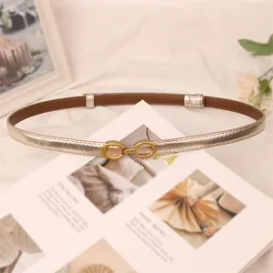 Women thin gold dress belt with elegant interlocking metal buckle for stylish outfits.