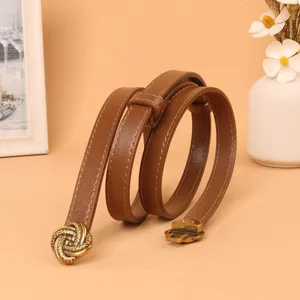 Brown skinny belt detail showing vintage metal buckle design and fine texture for elegant wear.