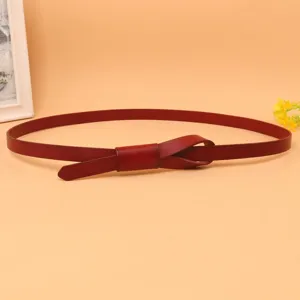 Close-up of a slim burgundy leather belt for women with a knotted bow design
