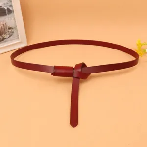 Close-up of wine red slim leather belt with a knot design for women's dresses