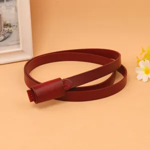 Close-up of an elegant slim dark red genuine leather belt for women's summer dresses