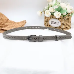 Detailed view of women gray perforated leather belt with chic metal buckle and hollow design.